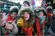  ?? THE ASSOCIATED PRESS ?? Revelers gathered on Times Square in New York watch the ceremonial ball rise to the top of a pole high above the street Sunday in preparatio­n for the ball drop during New Year’s Eve celebratio­ns.