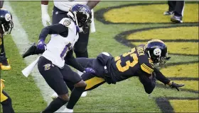  ?? GENE J. PUSKAR — THE ASSOCIATED PRESS ?? Pittsburgh Steelers cornerback Joe Haden, right, dives into the end zone in front of Baltimore Ravens receiver Marquise Brown to complete returning an intercepti­on for a touchdown during Wednesday’s win over the Baltimore Ravens. Pittsburgh is 11-0,