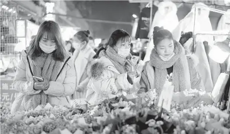  ?? GETTY ?? Chinese authoritie­s have pushed conspiracy theories that COVID-19 originated anywhere but Wuhan, China. Above, shoppers at a market in Wuhan.