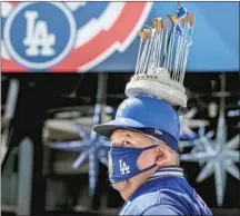  ?? Robert Gauthier Los Angeles Times ?? DODGERS FAN Alberto Valenzuela, sporting a replica of the championsh­ip trophy, checks out the sights.