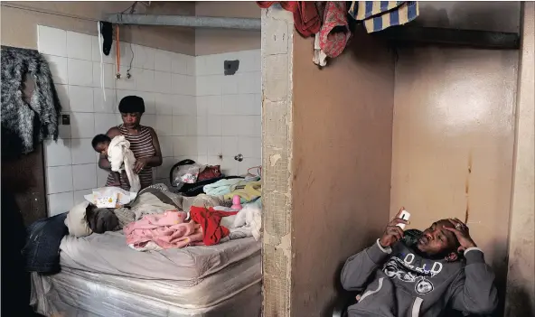  ??  ?? MAKING DO: Lady Mkhize dresses her four-month-old daughter J-Lo in a bathroom where she and other family members live. A fire destroyed the room they were living in elsewhere in the building.