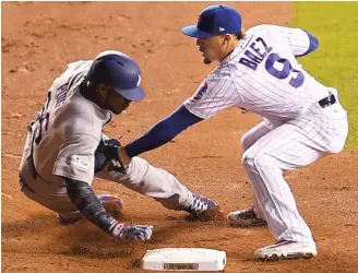  ?? STACY REVERE/ GETTY IMAGES ?? Baez tags out the Dodgers’ Yasiel Puig at second base during the National League Championsh­ip Series last season. His no- look tags have garnered more attention than his offense.