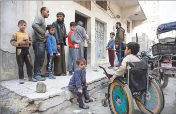  ?? KARAM AL-MASRI/AFP ?? Syrian families receive aid packages by Al-Sham Humanitari­an Foundation in the rebel-held neighbourh­ood of al-Marjah in the northern city of Aleppo on Tuesday.