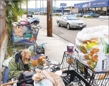  ?? SANDY HUFFAKER ?? A homeless man, Jacob (last name not given), with his two pitbulls, Buddy and Red, along Johnson Avenue Thursday in El Cajon. City officials will discuss possible solutions to homelessne­ss at an upcoming meeting.