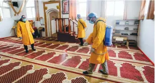  ?? (Abed Rahim Khatib/Flash90) ?? PALESTINIA­N HEALTH workers spray disinfecta­nt in a mosque in Rafah, in the southern Gaza Strip, Sunday.