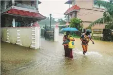  ?? PTI ?? Locals wade through a flood affected area during heavy
■ rainfall in Kochi on Friday.