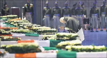  ??  ?? Prime Minister Narendra Modi pays tribute to the martyred CRPF jawans at the Palam air force station in New Delhi on Friday.