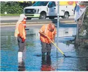  ?? JOECAVARET­TA/SUNSENTINE­L ?? Broward County workers clear a storm drain Tuesday on Northwest 31st Avenue.