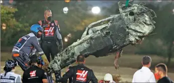  ?? REUTERS ?? The charred wreckage of Romain Grosjean’s cockpit is removed from the track at Bahrain Internatio­nal Circuit following the Haas driver’s crash. The car’s ‘halo’ protection system, which surrounds the driver’s head, was credited with saving the 34-year-old’s life.