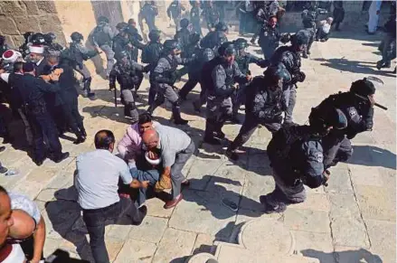  ?? (Foto REUTERS) ?? Anggota polis Israel mengejar jemaah Palestin di pekarangan masjid Al-aqsa di Kota Lama Baitulmaqd­is, semalam ketika sambutan Hari Raya Aidiladha.