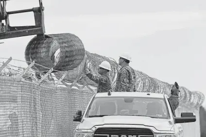  ?? Photos by Jerry Lara / Staff photograph­er ?? Texas National Guard soldiers work to install fencing along Vega Verde Road in Del Rio last week. The road hugs the Rio Grande.