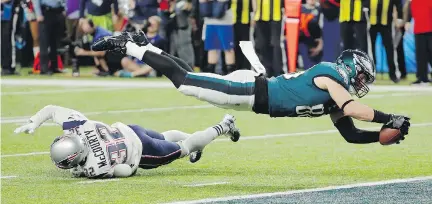  ?? FRANK FRANKLIN II/THE ASSOCIATED PRESS ?? Philadelph­ia tight end Zach Ertz dives into the end zone over New England free safety Devin McCourty for the game-winning touchdown.