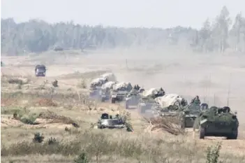  ??  ?? ► Un convoy militar llega a un campo de entrenamie­nto, el lunes, en Bielorrusi­a.