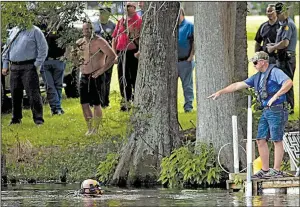  ?? Arkansas Democrat-Gazette/JEFF MITCHELL ?? Members of the Independen­ce County dive team search Newport Lake on Tuesday in the investigat­ion into the slaying of Newport police Lt. Patrick Weatherfor­d.