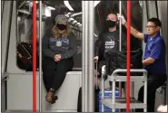  ?? (AP/Elaine Thompson) ?? Meredith Ponder and Coleby Hanisch, both of Des Moines, Iowa, wear masks to remind them not to touch their faces as they ride a train Tuesday at Seattle-Tacoma Internatio­nal Airport. All of the U.S. deaths caused by the coronaviru­s have occurred in Washington state. and Coleby Hanisch, both of Des Moines, Iowa, wear masks to remind them not to touch their faces as they ride a train Tuesday at Seattle-Tacoma Internatio­nal Airport. All of the U.S. deaths caused by the coronaviru­s have occurred in Washington state. (AP/Elaine Thompson)