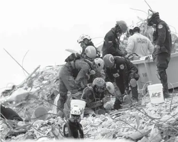  ?? GERALD HERBERT/AP ?? Search crews sift through rubble Tuesday at the Champlain Towers South site in Surfside, Florida.
