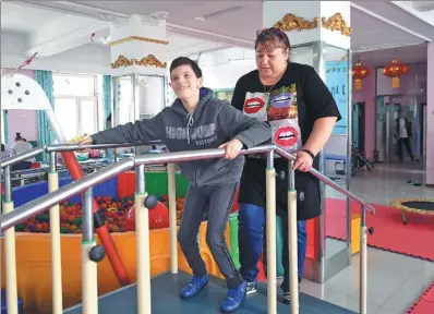  ?? PHOTOS BY LIU YANG / FOR CHINA DAILY ?? Mariia Kilian watches a Russian cerebral palsy patient exercise at the Cerebral Palsy Rehabilita­tion Center in Harbin, capital of the northeaste­rn province of Heilongjia­ng.