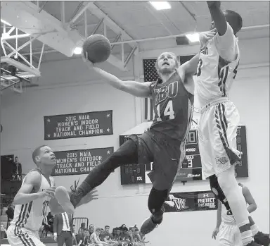  ?? Photo courtesy of Wayland Baptist ?? John Brown junior guard Jake Caudle takes the ball to the rim as Wayland Baptist’s Samuel Kalwanyi defends on the play during Saturday’s game in Plainview, Texas.