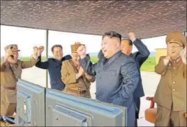  ?? AFP FILE ?? North Korean leader Kim JongUn (centre) celebrates a successful rocket launch.