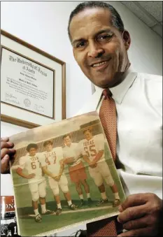  ??  ?? In this Dec. 16, 2005 photo, Dallas attorney and former Texas football player Julius Whittier holds a newspaper clipping from 1971 featuring Whittier with teammates Bruce Cannon, Greg Dahlberg, and coach Darrell Royal in Dallas. TIM SHARP/AUSTIN AMERICAN-STATESMAN VIA AP