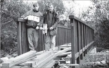  ?? 01_B42twe04 ?? A year ago we reported on the Cordon footbridge over the Monamore Burn being swept away in the October floods. This week it has been replaced with a new sturdy structure which the builders say will be there for many years to come. Our picture shows Gareth Hopps and Anthony Brown applying the finishing touches.