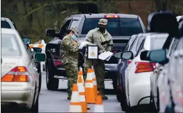  ?? MARK HUMPHREY — THE ASSOCIATED PRESS ?? National Guard personnel check in people as they wait to receive a COVID-19 vaccinatio­n Friday in Shelbyvill­e, Tenn.