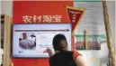  ?? — Reuters ?? A customer points at a screen displaying a website of Alibaba’s Taobao at a rural service centre in Yuzhao Village, Tonglu, Zhejiang province, China.