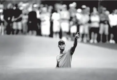  ??  ?? Tiger Woods points to his shot on the eighth fairway Tuesday during a practice round for the Masters golf tournament in Augusta, Ga.