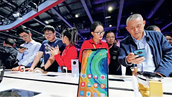  ??  ?? The 2019 China Mobile Worldwide Partner Conference opens in Guangzhou on November 14, 2019. Citizens visiting Huawei 5G exhibition area try out 5G mobile phones.
