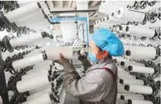  ?? — AFP ?? An employee works at a textile factory in Lianyungan­g in China’s eastern Jiangsu province.