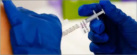  ?? ?? A health worker administer­s a dose of a Moderna Covid-19vaccine in Norristown, Pa., Tuesday, Dec. 7, 2021.