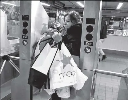  ?? REUTERS ?? A holiday shopper enters the New York City subway following Black Friday shopping in New York.