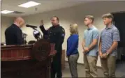  ??  ?? Troy Mayor Patrick Madden, left, swears in Capt. Adam Mason in City Hall Tuesday morning as Mason’s wife, Kristi, and son’s Morgan and Damon look on.