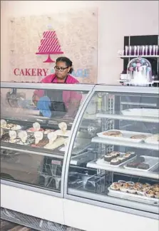  ??  ?? Sanaa Smith, 14, of Wilkinsbur­g cleans the gelato case.