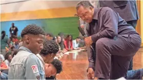  ??  ?? Rev. Jesse Jackson answers a student’s question about a voting applicatio­n form at Booker T. Washington High School on Monday. BRANDON DAHLBERG / FOR COMMERCIAL­APPEAL.COM