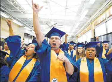  ?? Richard Brian ?? Las Vegas Review-journal @vegasphoto­graph Michael Alexander, center, an overnight support manager at Walmart, celebrates with colleagues Tuesday during the first graduation ceremony for the retailer’s Las Vegas Training Academy.