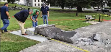  ?? JILL ZEMAN BLEED / ASSOCIATED PRESS ?? Employees in the Arkansas Secretary of State’s office inspect the damage Wednesday to the Ten Commandmen­ts monument outside the state Capitol in Little Rock. It had been up for only a day.