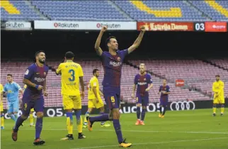  ?? Manu Fernandez / Associated Press ?? Barcelona’s Sergio Busquets celebrates his goal before empty seats at Camp Nou. The game was played without fans amid the referendum on Catalonia’s independen­ce.