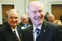  ?? Associated Press ?? ■ Arkansas Gov. Asa Hutchinson prepares to speak to a joint session of legislator­s Monday at the state Capitol in Little Rock. Behind him is Arkansas Treasurer Dennis Milligan. The governor told lawmakers that next year he would like them to cut the...