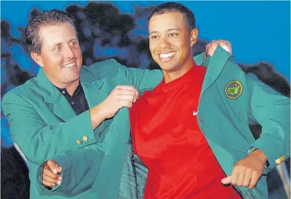  ?? AFP ?? 2005. Mickelson le coloca el tradiciona­l saco verde a Woods. Fue su cuarto y último festejo en Augusta.