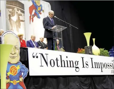  ?? FOR DIGITAL FIRST MEDIA — KIRK NEIDERMYER ?? Giant illustrate­d props of Albert Boscov dressed as a superhero taking flight were placed on stage inside Santander Arena in Reading during a memorial service for the retail giant Sunday.