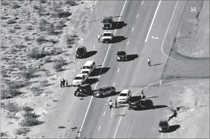  ?? L.E. BASKOW/LAS VEGAS REVIEW-JOURNAL VIA AP ?? In this 2020, file photo, Nevada Highway Patrol investigat­e the scene of a fatal crash involving multiple bicyclists and a box truck along U.S. Highway 95 southbound near Searchligh­t, Nev.