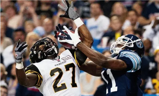  ?? AARON VINCENT ELKAIM / THE CANADIAN PRESS ?? The Argos’ Dontelle Inman battles the Tiger-Cats’ Delvin Breaux on Friday at the Rogers Centre, in a game that featured no
shortage of offence. The defending Grey Cup champions held on to win their home opener 39-34 before a large crowd.