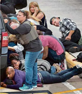  ?? Allen Eyestone/”The Palm Beach Post”/Xinhua ?? Passageiro­s e visitantes se agacham durante os disparos no aeroporto de Fort Lauderdale