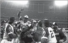  ?? CHARLES KNOBLOCK/AP PHOTO ?? In this April 8, 1974, file photo, Atlanta Braves outfielder Hank Aaron, top, is congratula­ted by teammates at home plate after hitting his 715th career home run in a game against the Los Angeles Dodgers.