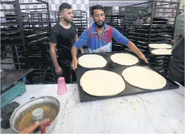  ?? AFP ?? Artisans prepare sweet bread at a bakery in Raqa, the city’s first after Syrian Democratic forces (SDF) drove the Islamic State (IS) group out of large parts of northern and eastern Syria.