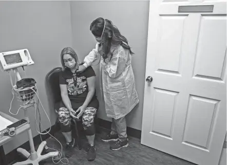  ?? ALTON STRUPP/COURIER JOURNAL ?? Nurse practition­er Katie Cornett, right, checks the lungs of patient Vickie Slone at a Primary Care Centers of Eastern Kentucky location in Hazard on Sept. 20, 2021.