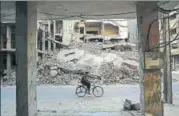  ?? AFP ?? A man rides past destroyed buildings in the rebelheld town of Douma, on the eastern outskirts of Damascus, on Saturday.