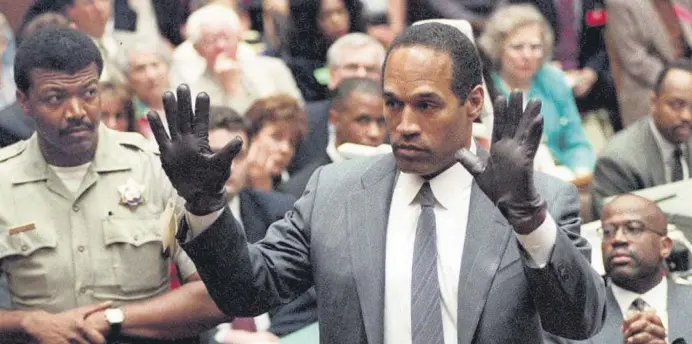  ?? ?? O.J. Simpson shows the jury a new pair of Aris extra-large gloves, similar to the gloves found at the Bundy and Rockingham crime scene during his double murder trial in Los Angeles, California, U.S., June 21, 1995.