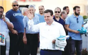  ?? (Amir Cohen/Reuters) ?? JOINT LIST HEAD Ayman Odeh hands out pamphlets during a campaign event in Tira earlier this month.